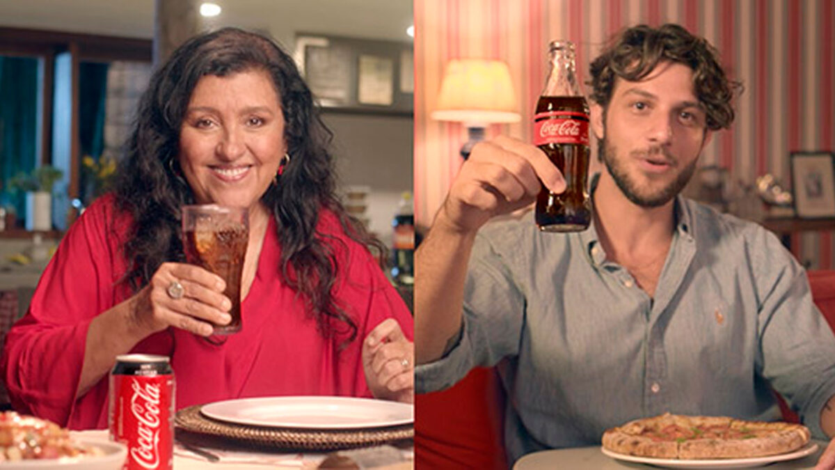 Regina Casé e Chay Sueade em cena final da novela Amor de Mãe. Ambos seguram um copo da Coca-Cola em ação comercial da novela.