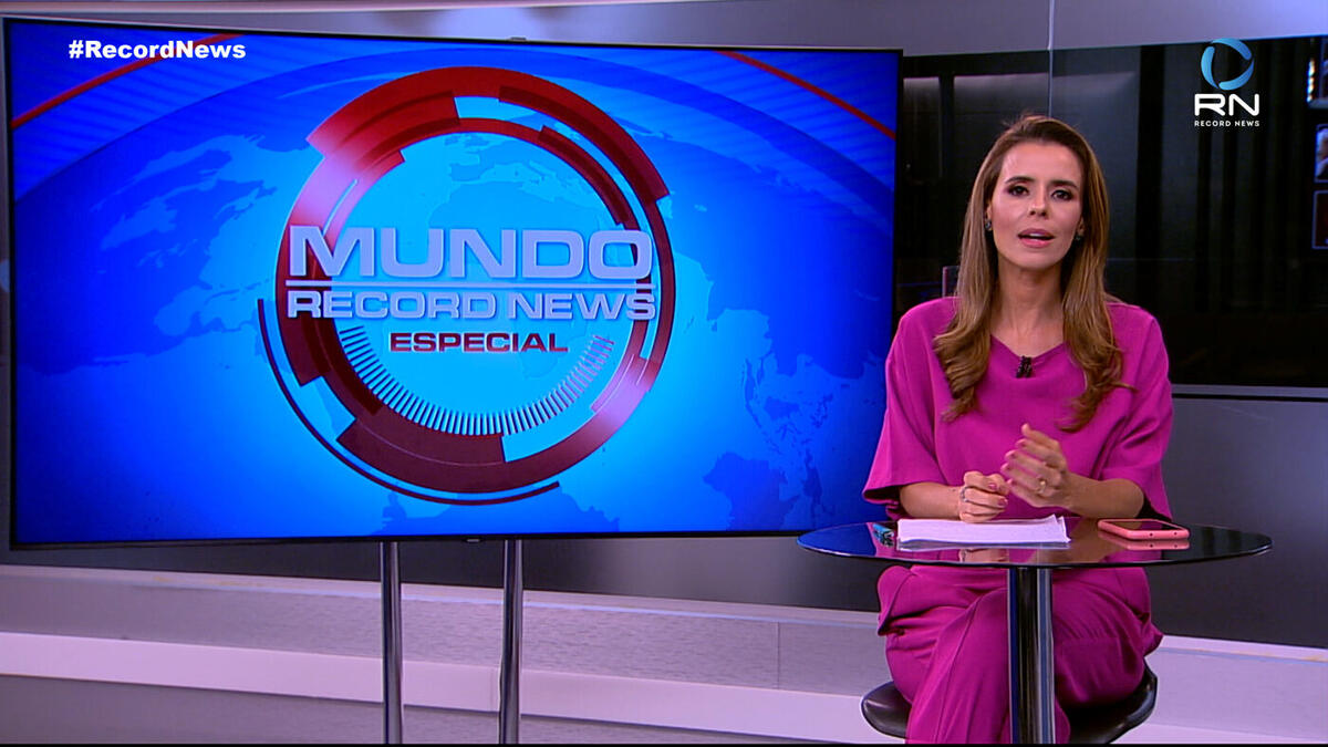 Renata Caetano em frente ao telão com o logo do Mundo Record News Especial