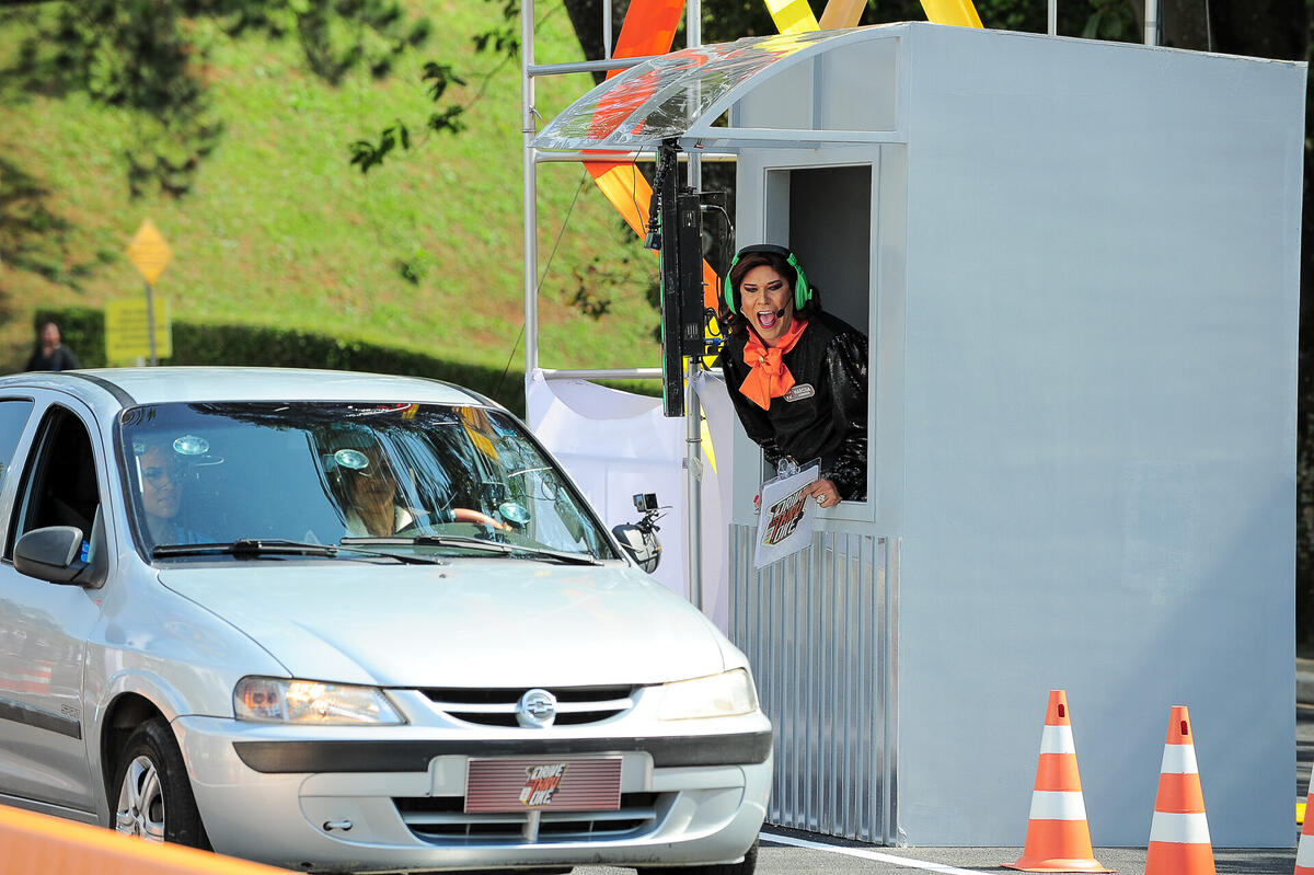 Narcisa abre a cancela do quadro Drive Thru Okê