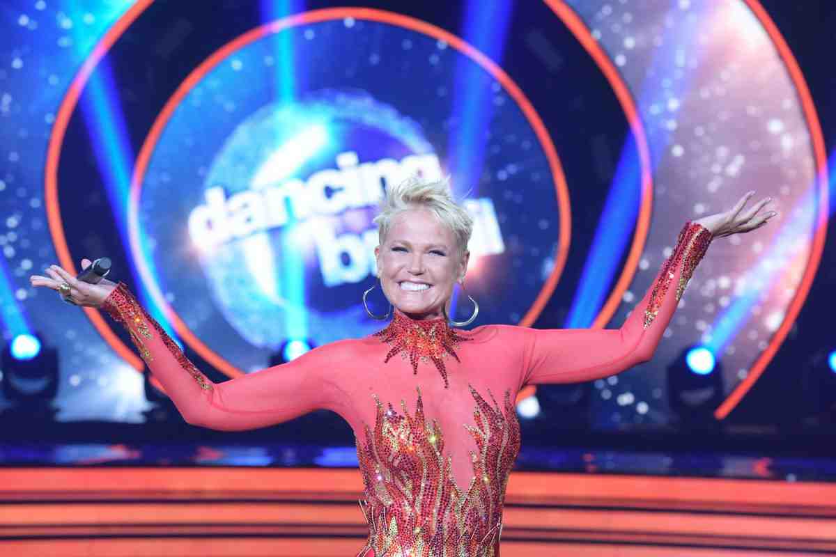 Xuxa no palco do Dancing Brasil com os braços levantados