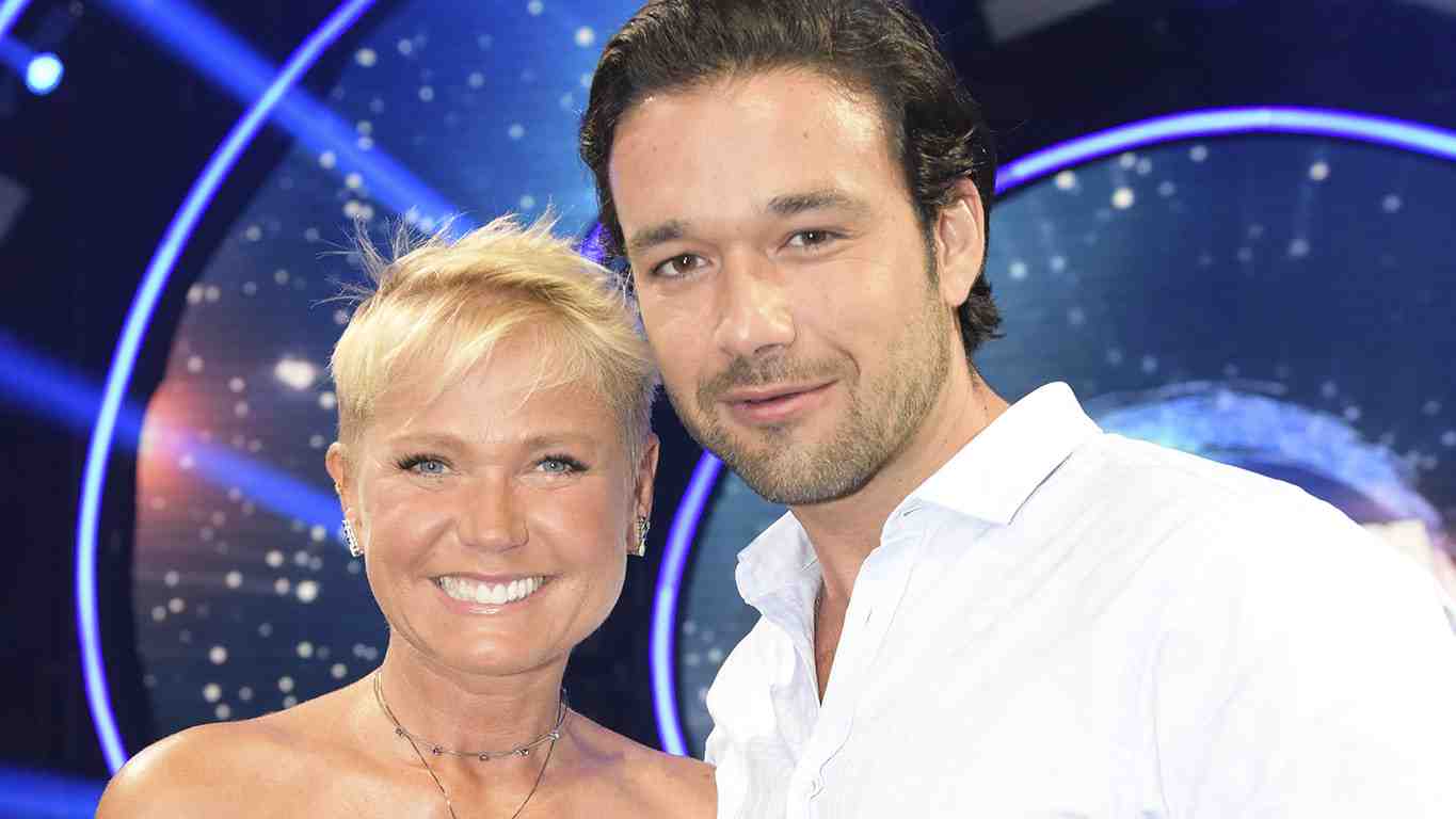 Xuxa está sorridente ao lado de Sergio Marone nos bastidores do Dancing Brasil