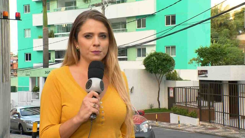 Renata Loures segurando o microfone da Record 