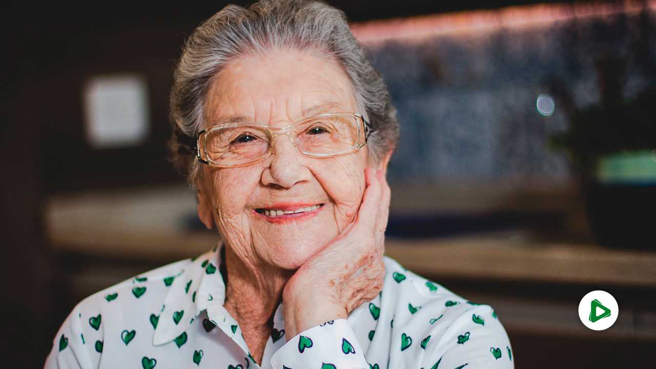 Palmirinha Onofre com a mão no queixo e sorrindo