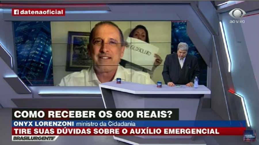 Mulher protesta na casa do ministro Lorenzoni durante entrevista no Brasil Urgente da Band