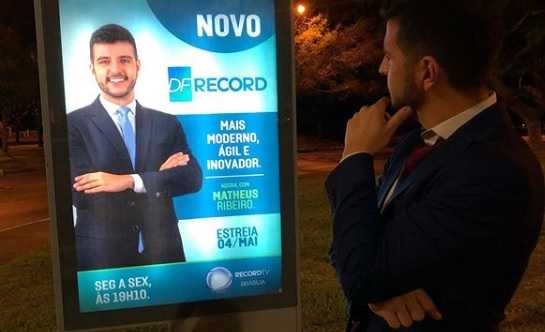 Matheus Ribeiro olha um dos Banners de divulgação na Record TV Brasília