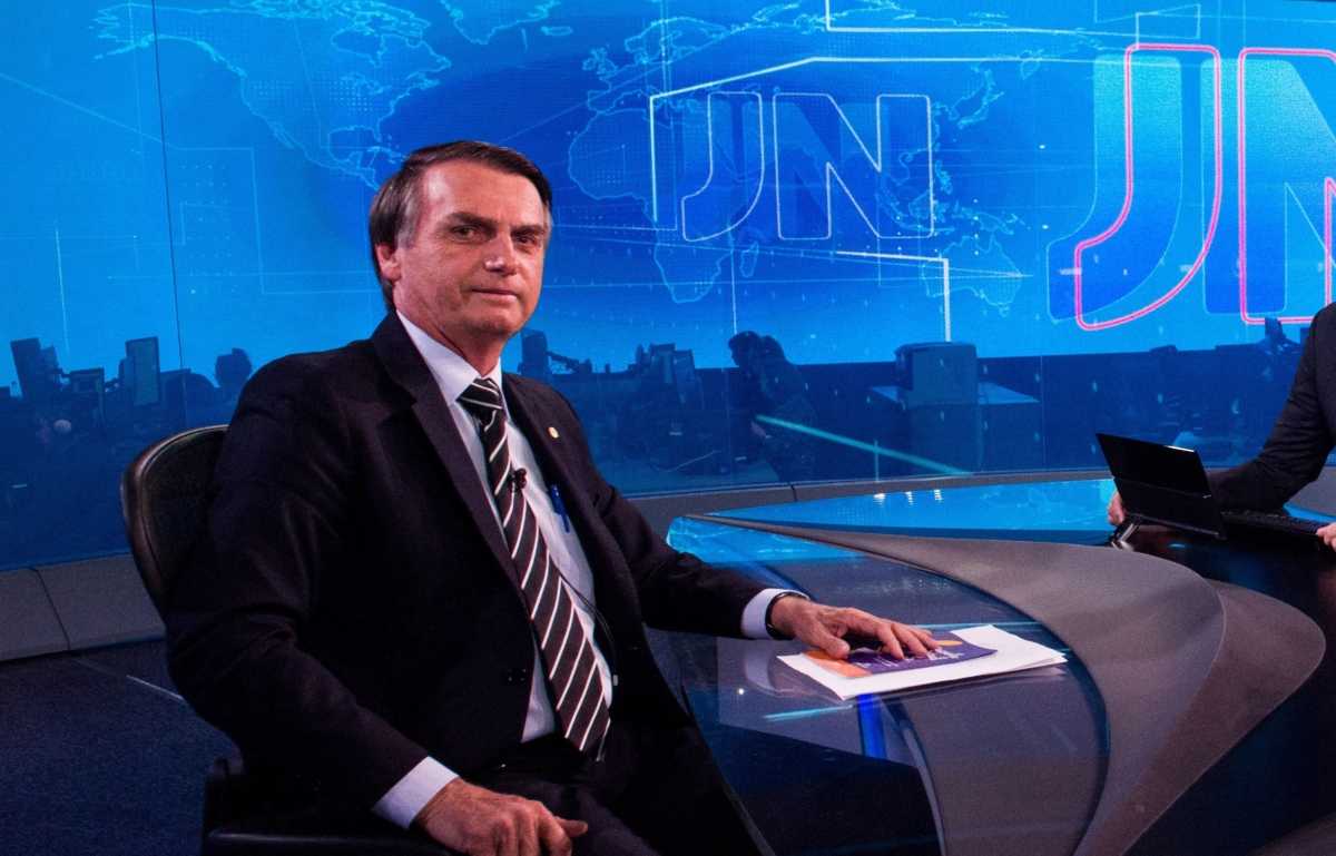 Jair Bolsonaro sentado na bancada do Jornal Nacional