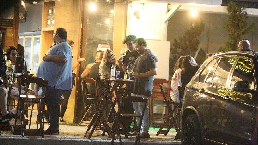 André Marques abraça amigos em restaurante