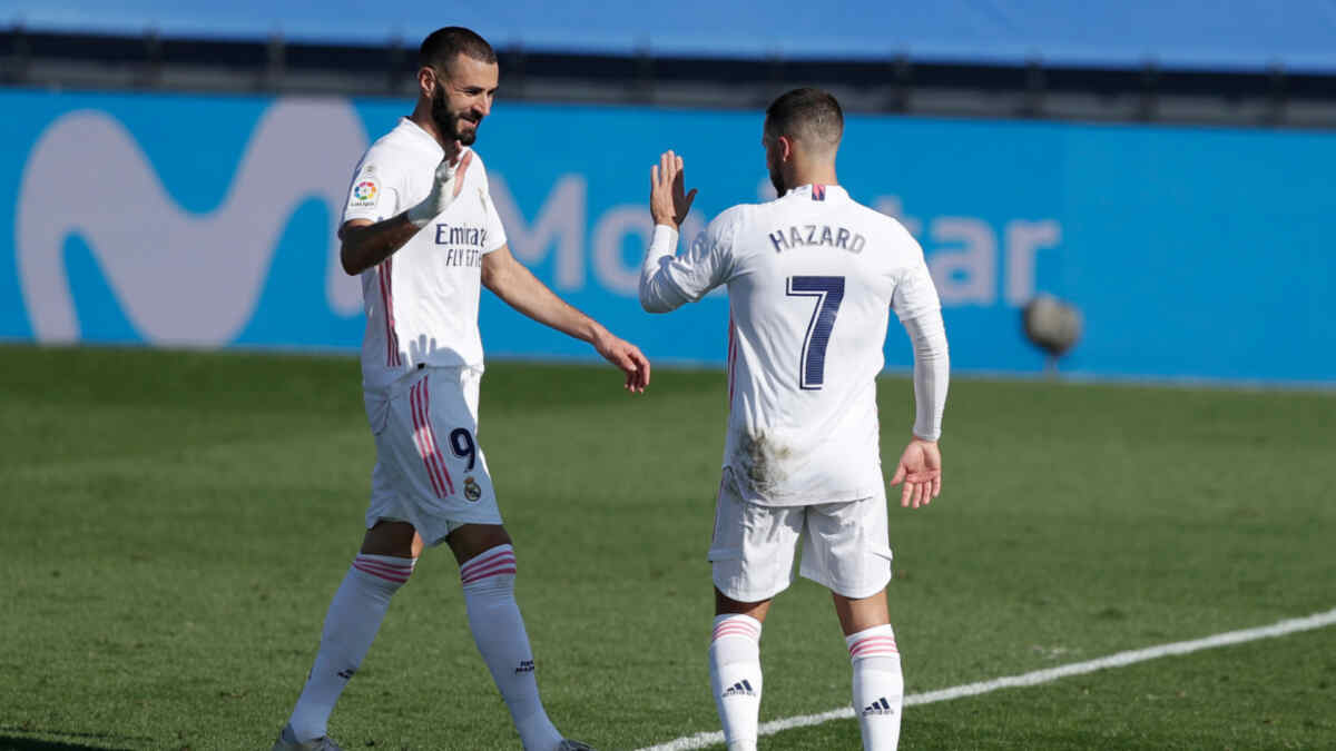 Jogadores Benzema e Hazard em campo com a camisa do Real Madrid