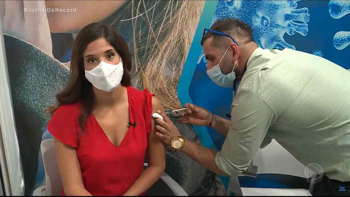 Enfermeiro aplica a primeira dose da vacina contra o covid-19 em Bianca Zanini, correspondente da Record TV em Israel