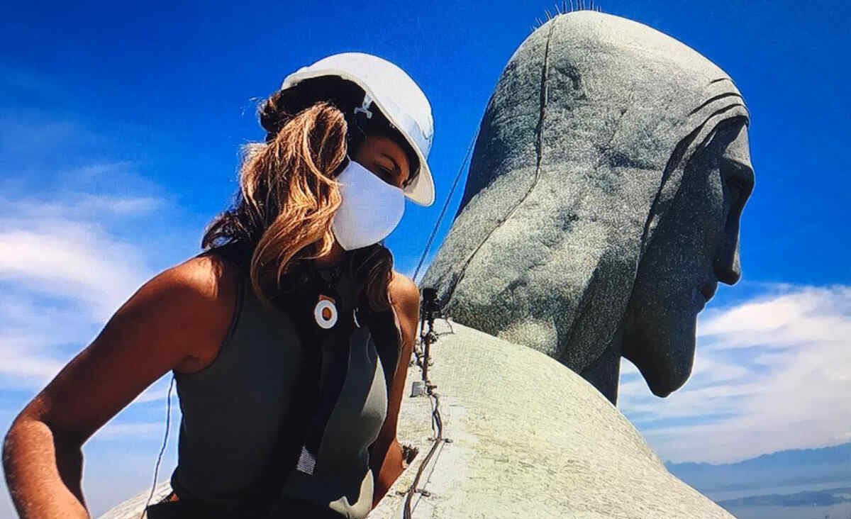 Repórter Fernanda Graell no ombro do Cristo Redentor durante as gravações do Globo Repórter