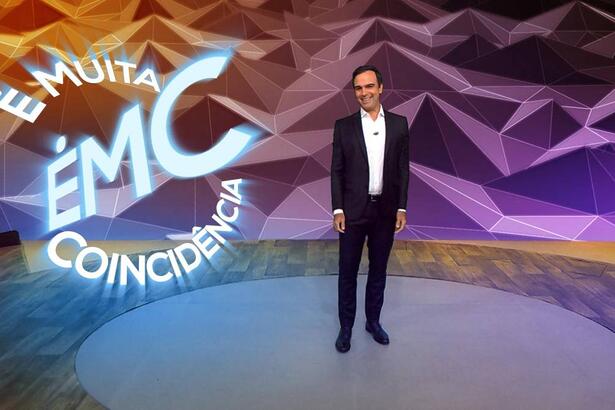 Tadeu Schmidt no cenário do Fantástico com o logo do novo quadro "É Muita coincidência"