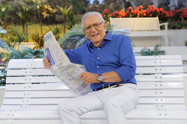 Carlos Alberto de Nóbrega sorrindo no banquinho de A Praça é Nossa