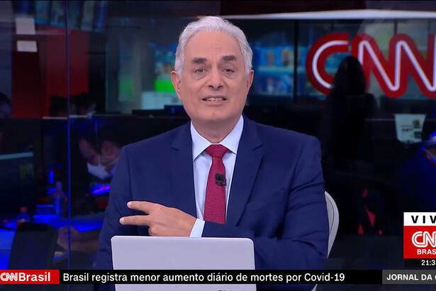 William Waack nos estúdios da CNN e aprontando com o braço que foi vacinado contra a covid-19