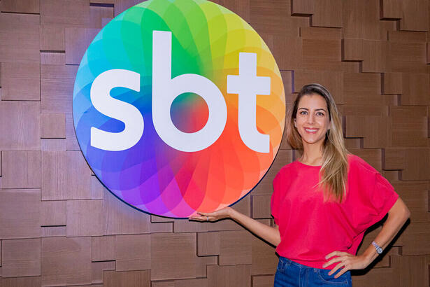 Domitila Becker na sede do SBT, em frente a logo do canal