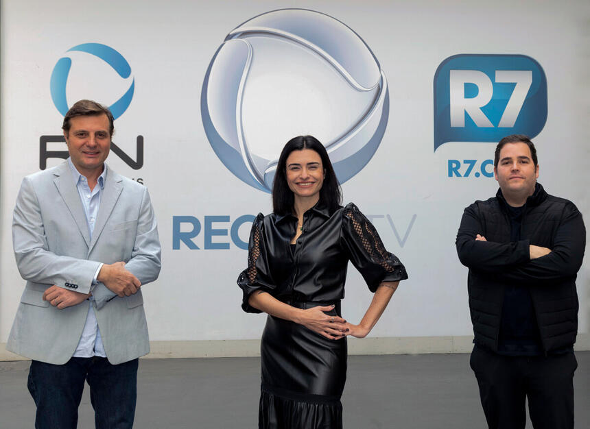 Guto Grieco, Sabrina Salado e Francisco Rosa posam em frente ao logo da Record TV, Recor News e Portal R7