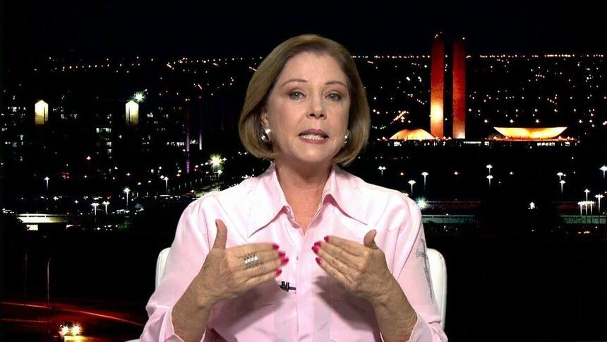 Eliane Cantanhêde gesticulando durante um comentário ao vivo na GloboNews, diretamente dos estúdios de Brasília