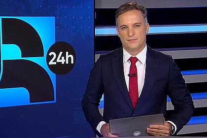 Leandro Stoliar segurando um tablet durante uma edição do JR24h