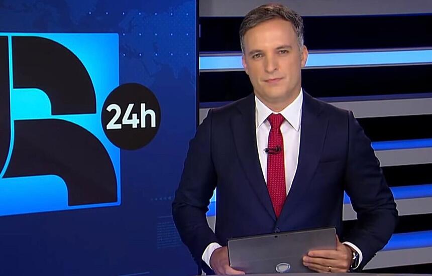 Leandro Stoliar segurando um tablet durante uma edição do JR24h