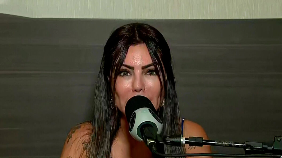 Liziane Gutierrez falando no microfone da Record TV na coletiva de A Fazenda 13