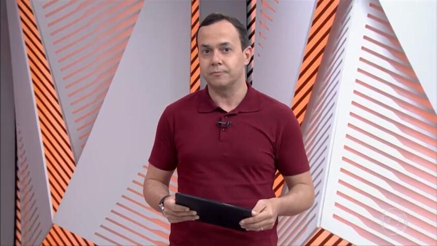 Tiago Medeiros nos estúdios do Globo Esporte RJ, segurando um tablet