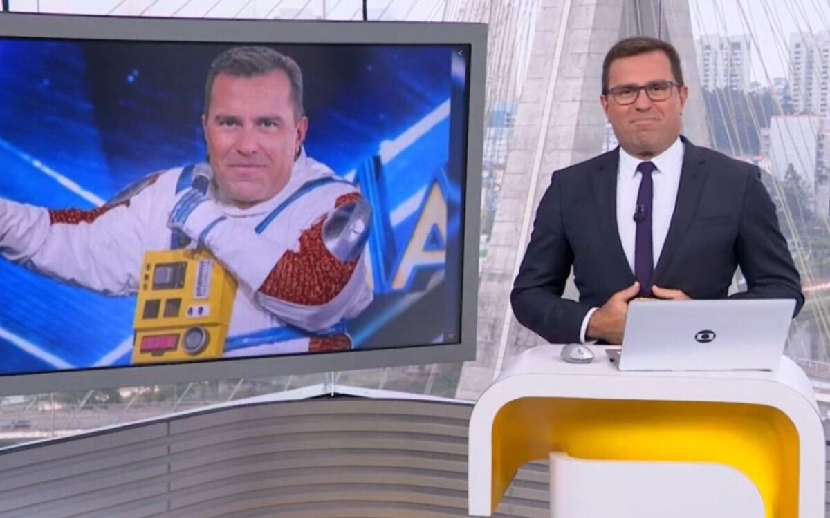 Rodrigo Bocardi no Bom Dia SP, com uma montagem dele vestido com a fantasia de Astronauta no telão dos estúdios