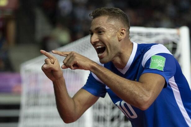 Jogador apontando para a câmera e comemorando um dos gols do Brasil pela Copa do Mundo de Futsal