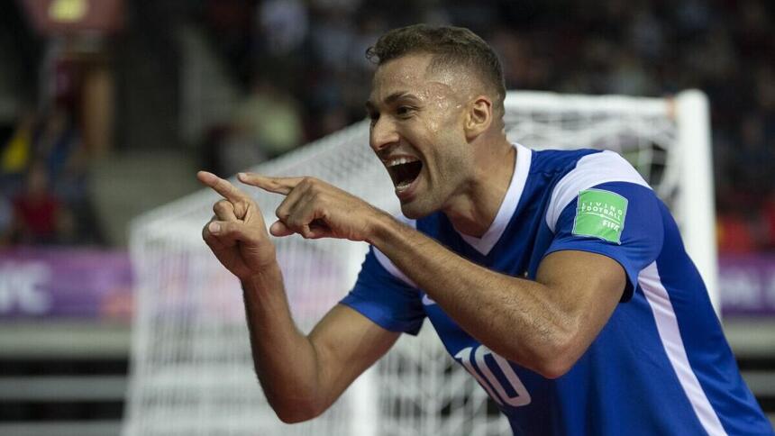 Jogador apontando para a câmera e comemorando um dos gols do Brasil pela Copa do Mundo de Futsal