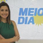 Anne Barreto na frente do logo do Meio Dia