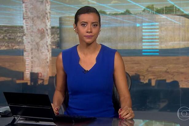 Aline Midlej com um vestido azul na bancada do Jornal nacional