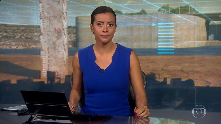 Aline Midlej com um vestido azul na bancada do Jornal nacional