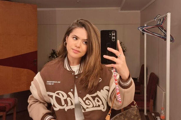 Maisa segura o telefone para tirar foto no espelho com o novo cabelo liso