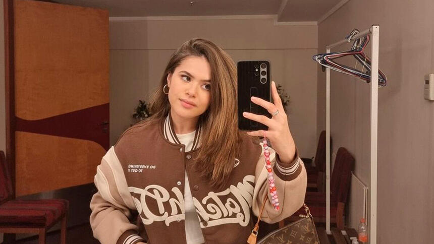 Maisa segura o telefone para tirar foto no espelho com o novo cabelo liso