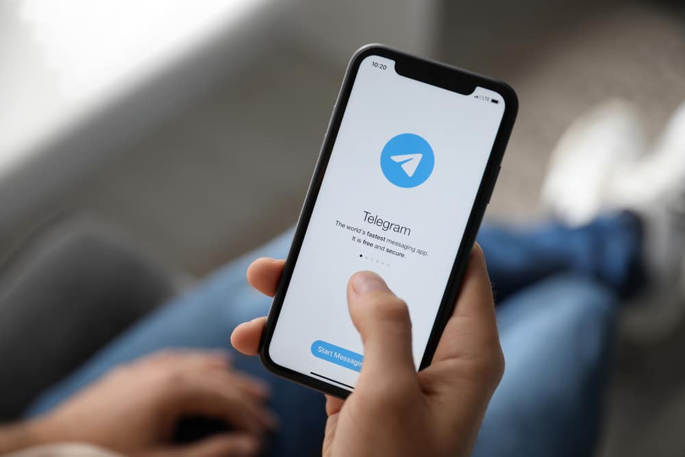 Usuário mexe no Telegram em um Iphone