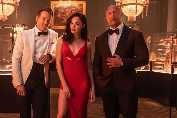 Ryan Reynolds, Gal Gadot e Dwayne Johnson vestidos com roupa de gala em cena do filme 'Alerta Vermelho' da Netflix