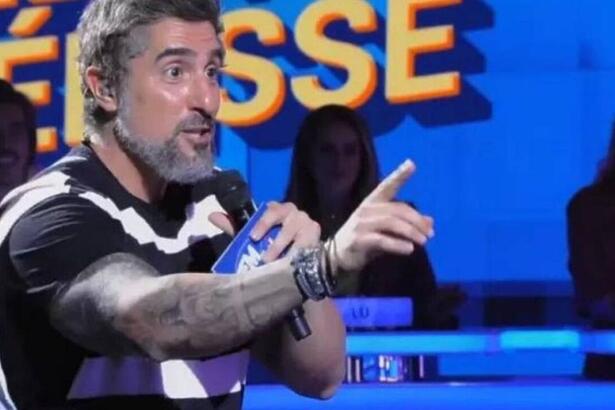 Marcos Mion durante o Caldeirão, nos estúdios do programa, com os braços a mostra e mostrando as tatuagens