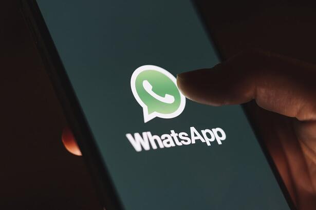 Mão segurando um Smartphone com o aplicativo do WhatsApp aberto