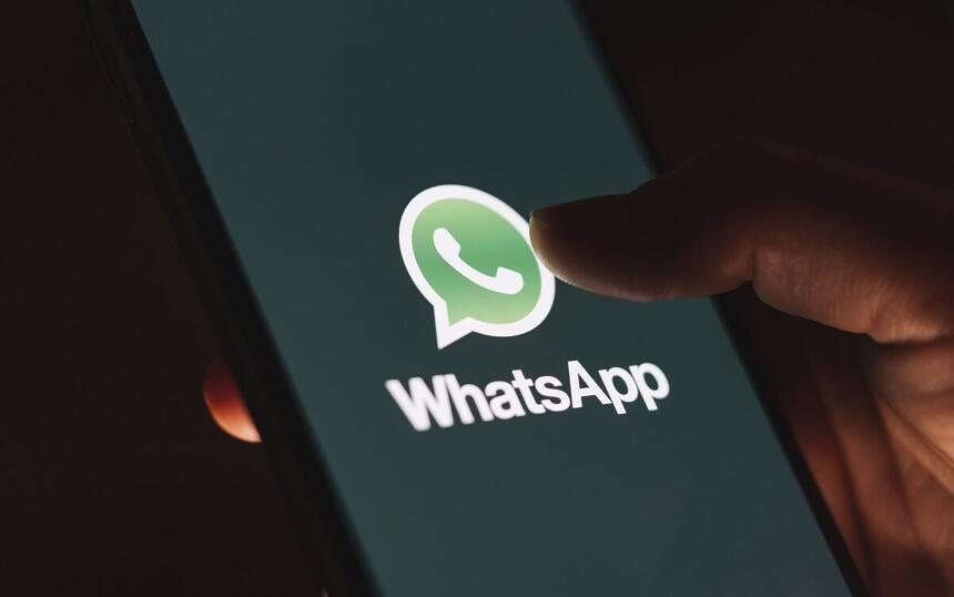 Mão segurando um Smartphone com o aplicativo do WhatsApp aberto