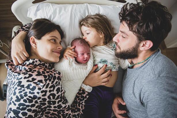 Chay Suede, ao lado de Laura Neiva e seus dois filhos, deitados