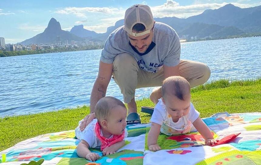 Joaquim Lopes ao lados das filhas em um gramado