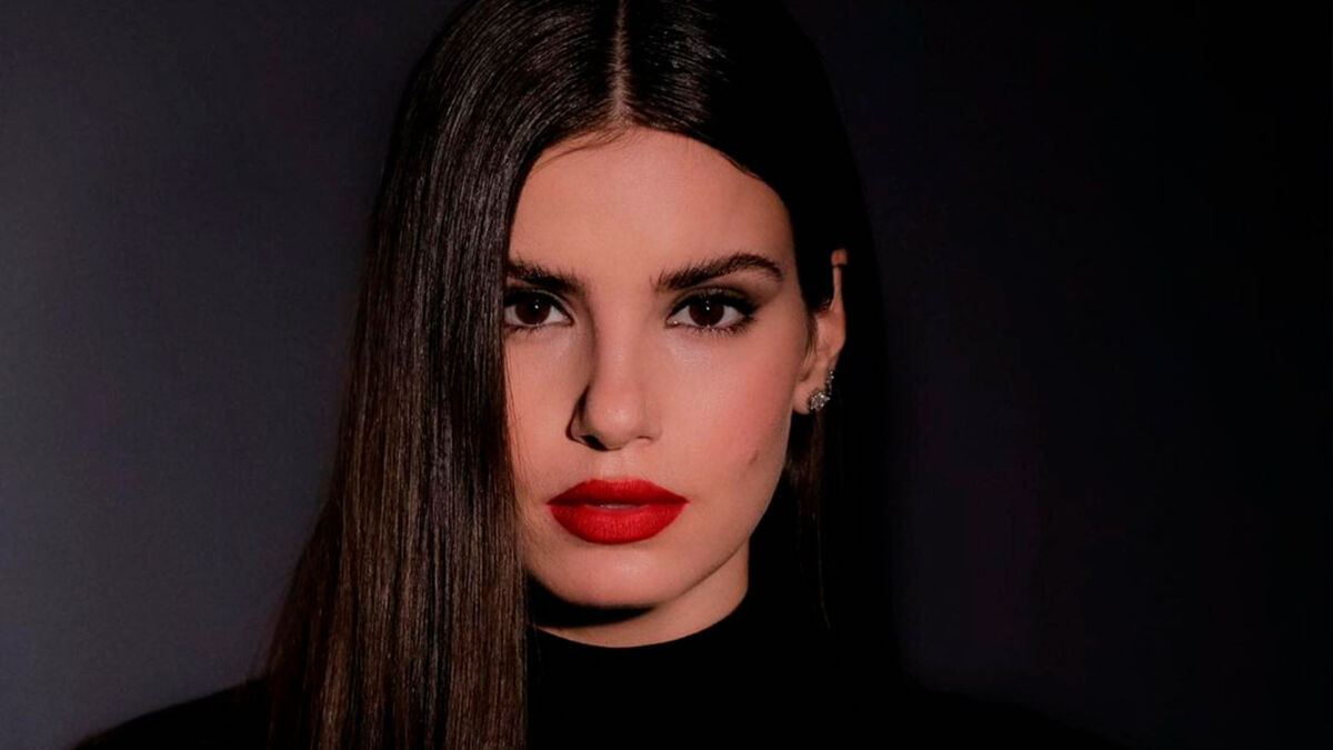 Camila Queiroz usa batom vermelho e roupa preta