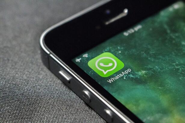 Ícone de logo do WhatsApp no canto superior esquerdo de um celular