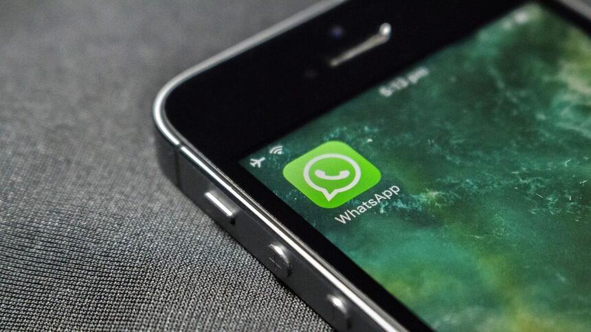 Ícone de logo do WhatsApp no canto superior esquerdo de um celular