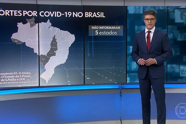 Bruno Tavares nos estúdios do Jornal Nacional em SP, em frente ao telão apresentando os dados da covid-19