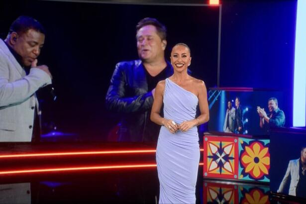 Sabrina Sato em pé de vestido cor de gelo, em frente ao telão do especial Leonardo & Raça Negra, na Record TV