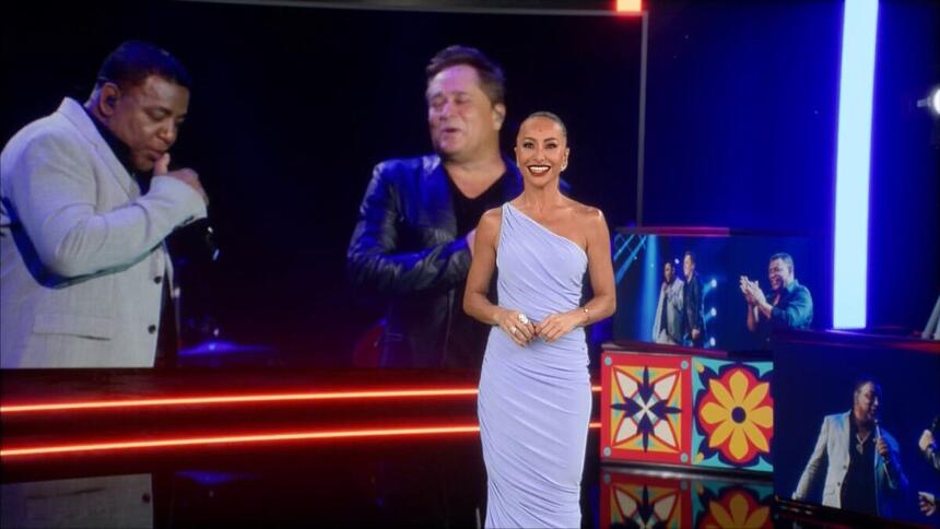 Sabrina Sato em pé de vestido cor de gelo, em frente ao telão do especial Leonardo & Raça Negra, na Record TV