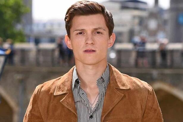 Tom Holland posa para foto com jaqueta marrom