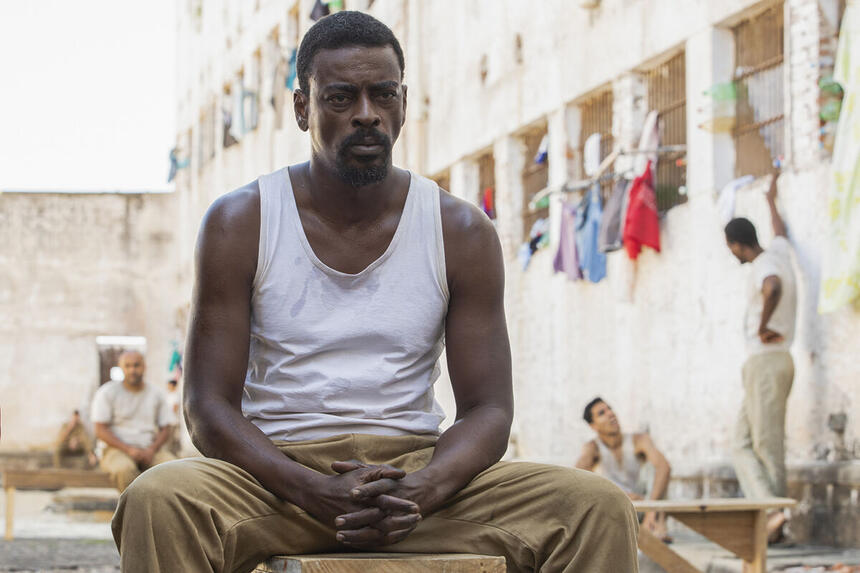 Seu Jorge em um set de presídio