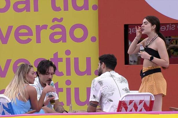 Rodrigo de costas, Eliezer e Bárbara sentados e Jade em pé chupando picolé durante ação no BBB 22.