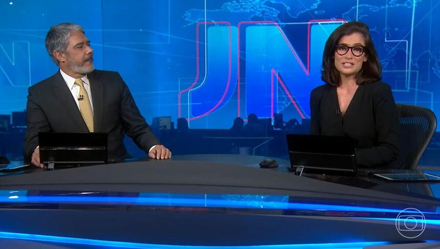 William Bonner e Renata Vasconcellos na bancada do Jornal Nacional, sentados lado a lado, na edição de 18 de janeiro de 2022