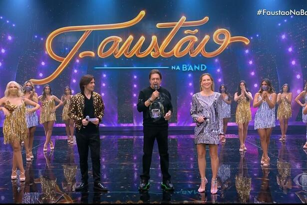 João Guilherme, Faustão e Anne Lotterman nos estúdios do programa Faustão Na Band, lado a lado, com as bailarinas ao fundo